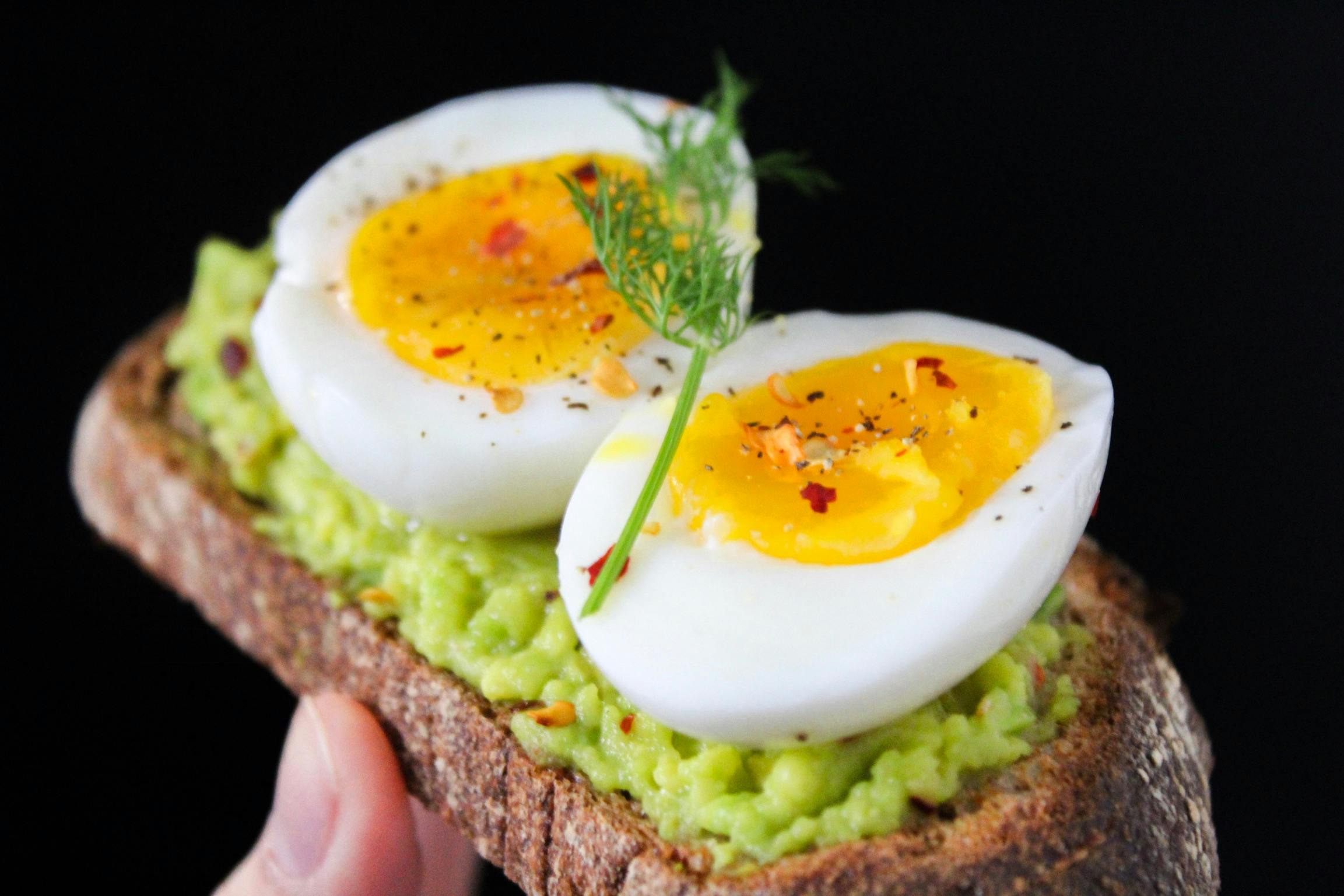 Colazione proteica sana con uovo a fette, insalata verde e pane integrale per uno stile di vita consapevole
