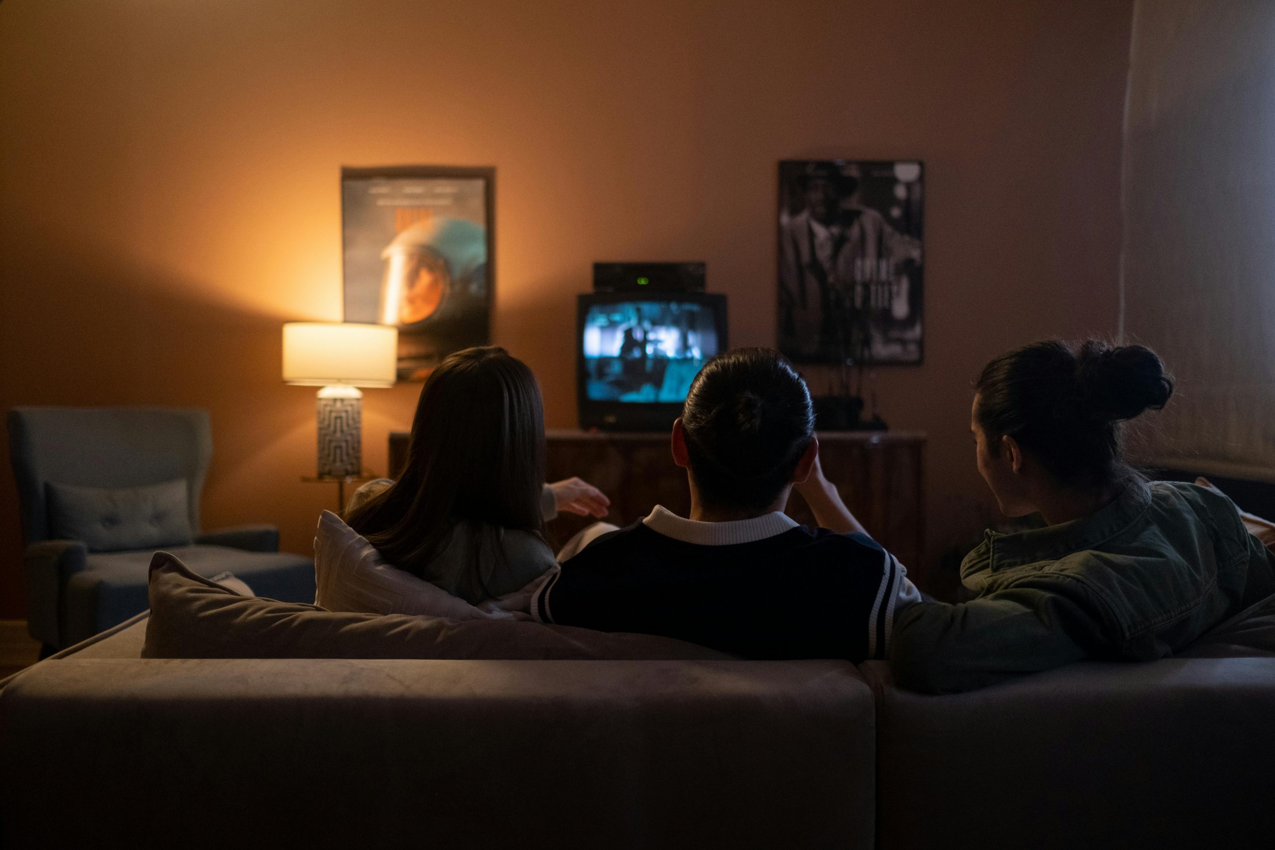 Tre persone che guardano una serie TV in un ambiente domestico, simbolo di apprendimento e riflessione sulla leadership